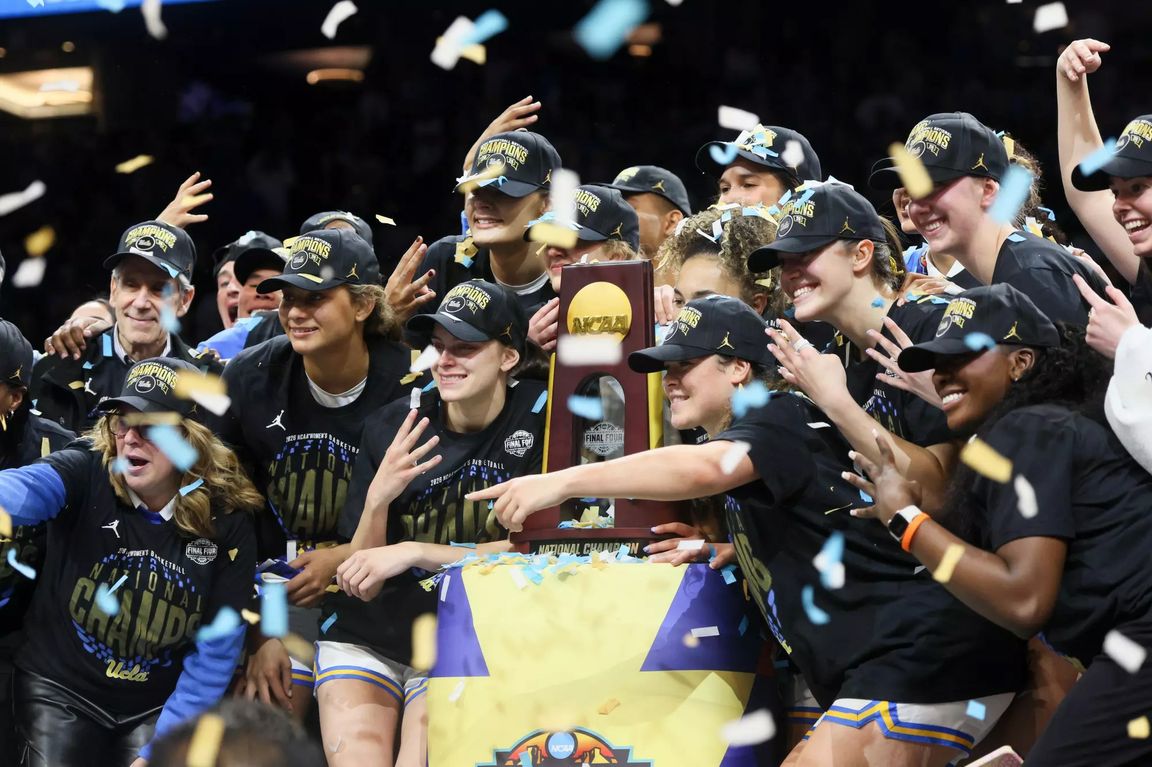 UCLA women's basketball team posing for photo with championship trophy