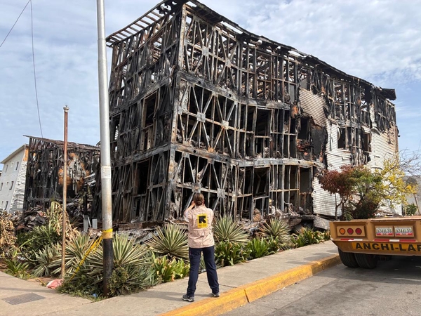 An IRC worker stands in front of damaged and collapsed buildings in La Guaira 1.5 weeks after the devastating twin earthquakes hit northern Venezuela.