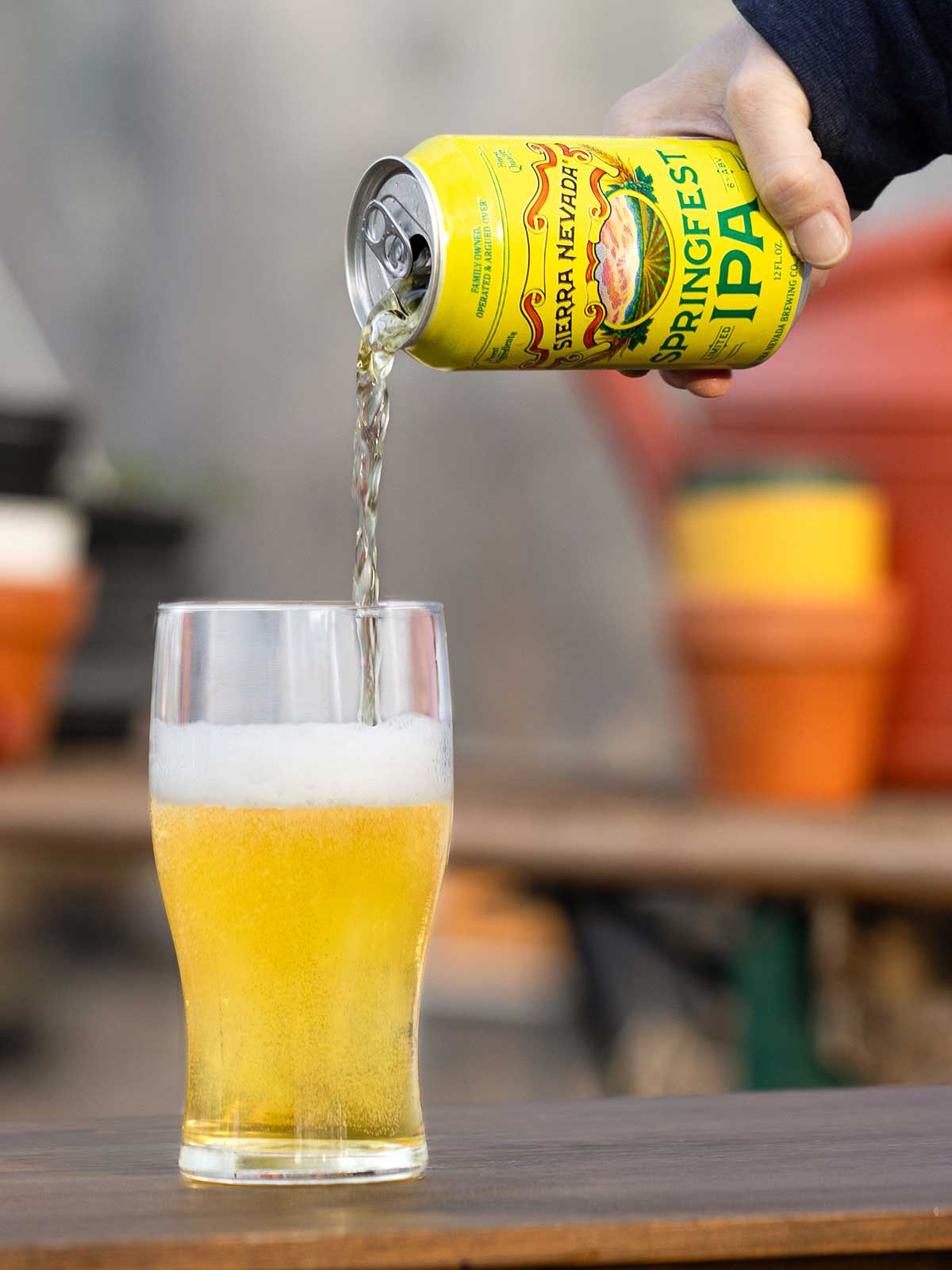 A hand pouring a can of Springfest into a pint glass