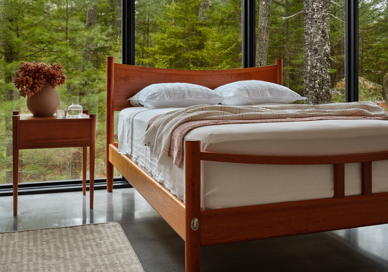 The Ellipse Platform Bed and side table shown in cherry.