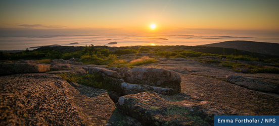 Sunrise over the ocean and rocky mountain-top at Acadia National Park