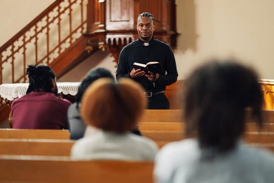 Young Black minister leads a church service.