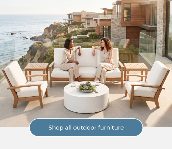 Two women relaxing on teak lounge furniture by the coast - Shop all outdoor furniture
