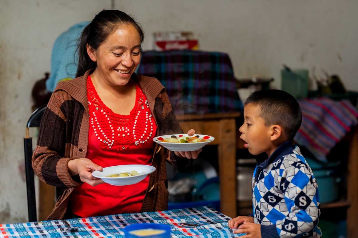 A woman serving food to her son.