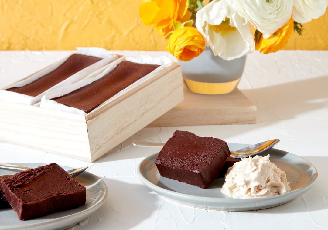The Tokyo Gâteaux Duo in a wooden box, alongside a few plated slices.