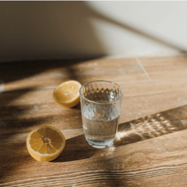 Lemon and glass of water on wooden bench