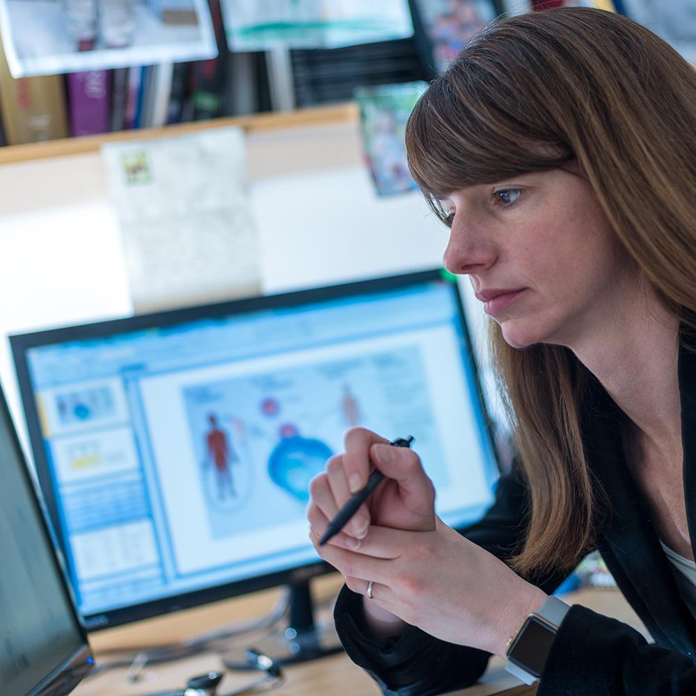 Caron Jacobson analyzing data on a workstation