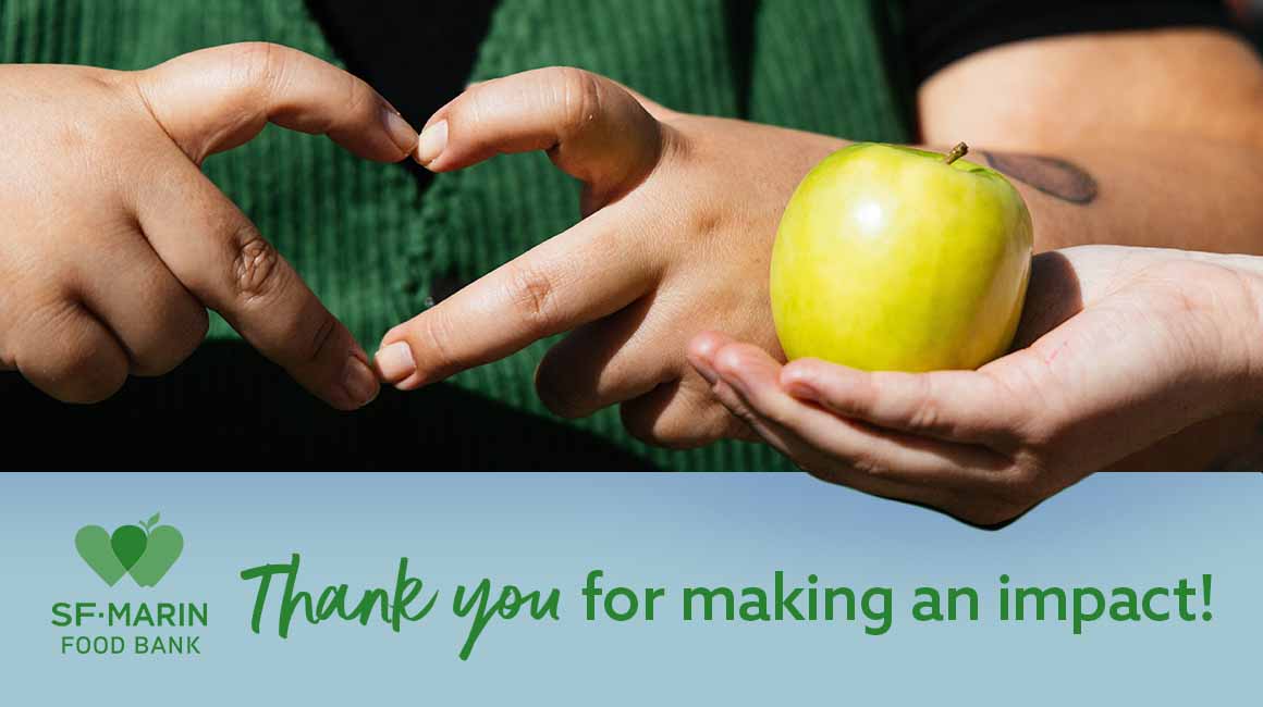 Heart shaped hands next to a green apple