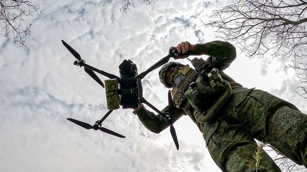 A drone unit operator of a motor rifle regiment of Russia's 49th Combined Arms Army with the Dnepr Group of Forces prepares a reconnaissance drone equipped with drop-off munition for flight in the zone of Russia's special military operation 