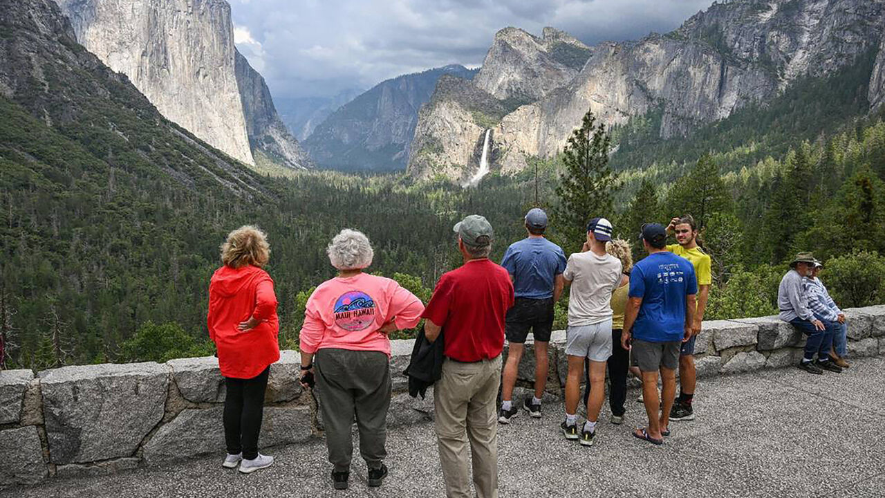 Yosemite National Park visitors look at El Capitan rock formation.
