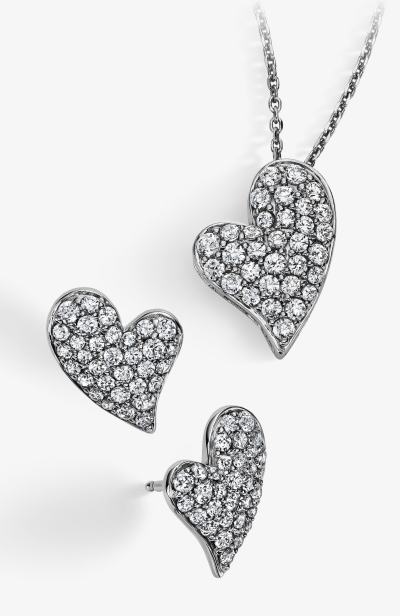 A heart-shaped multi-diamond necklace next to a pair of matching earrings.