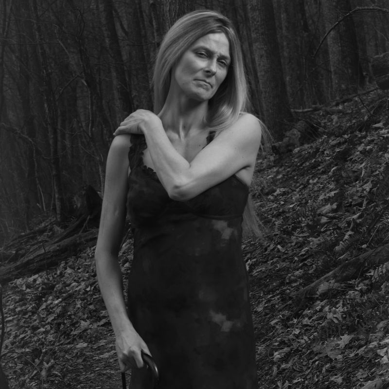 A black-and-white photograph of a woman in a dress. 