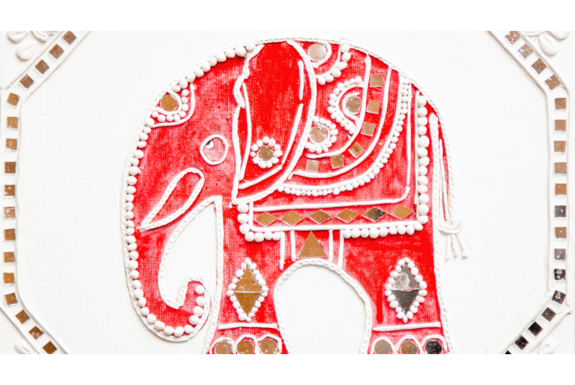 Clay tile decorated with a red elephant and small mirror tiles.