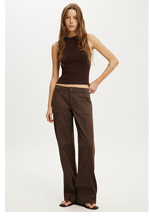 Woman wearing a brown sleeveless crop top and brown wide-leg pants with black slide sandals