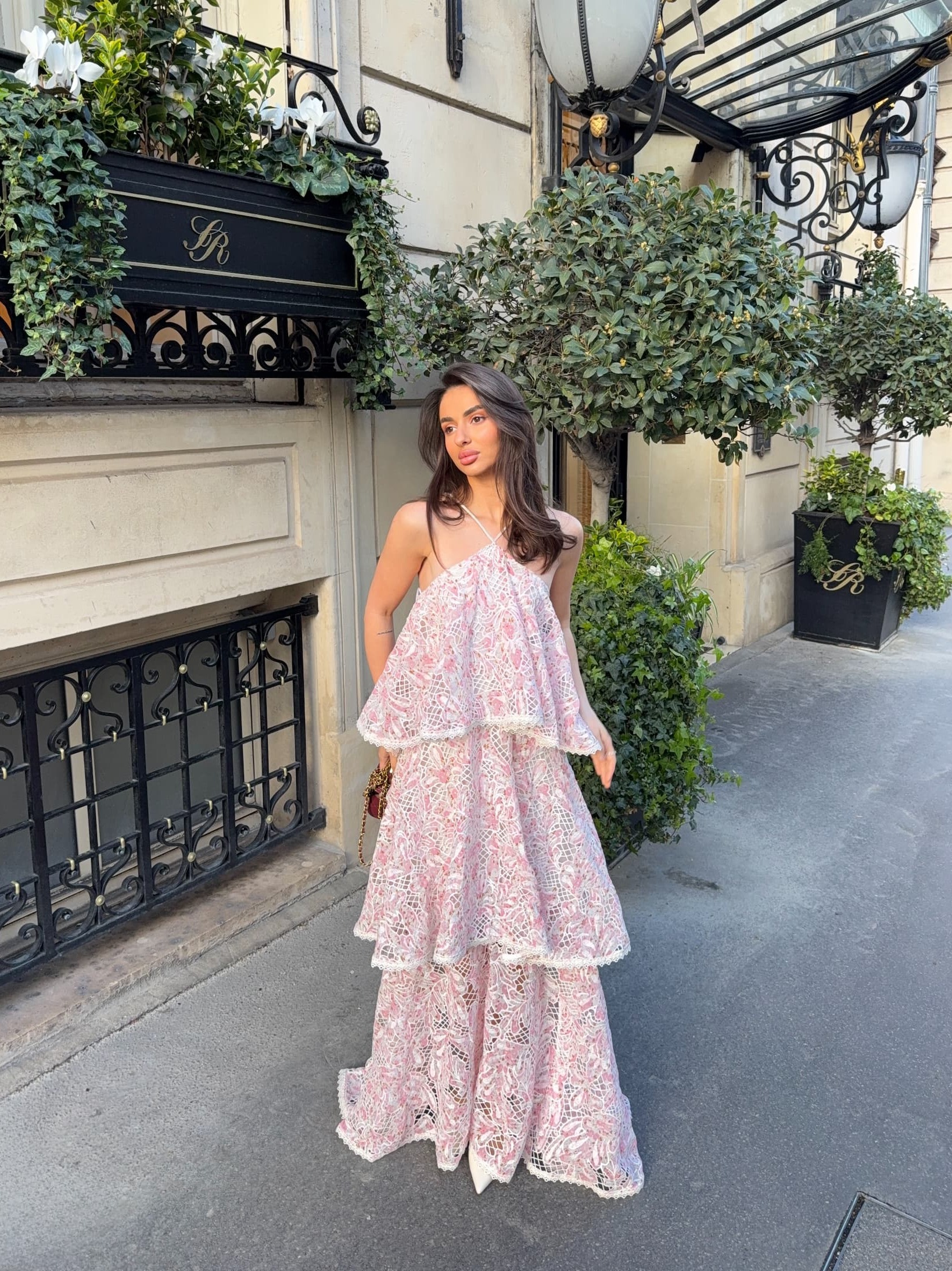 an image of a woman in a dress standing by a pillar