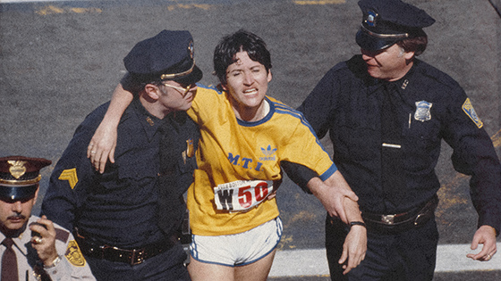 A runner helped by two policemen.