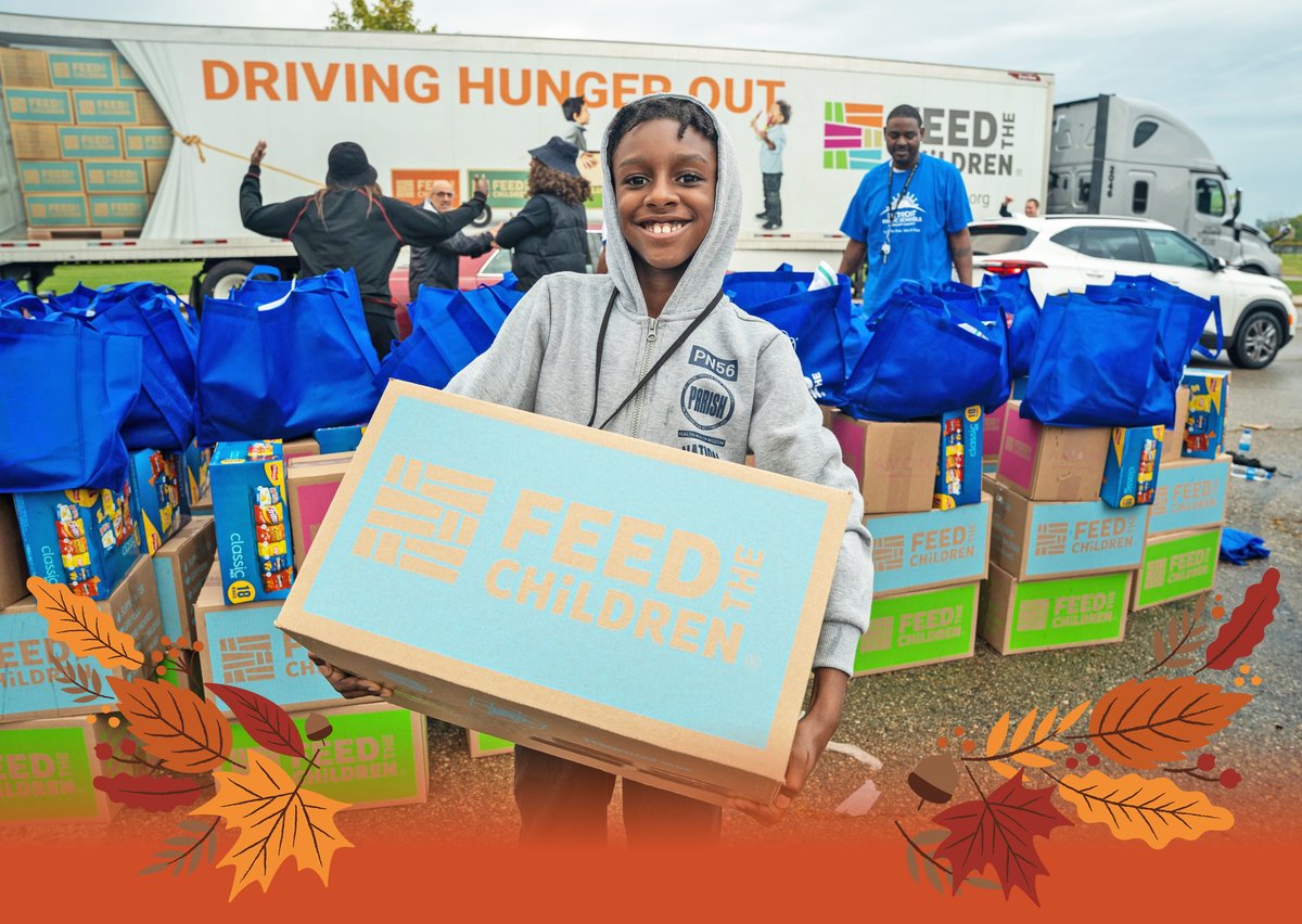 Young boy smiling after receiving a box filled with food.