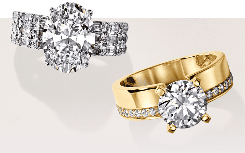 White gold engagement ring with an oval diamond and diamond-accented band beside a yellow gold round solitaire diamond ring.