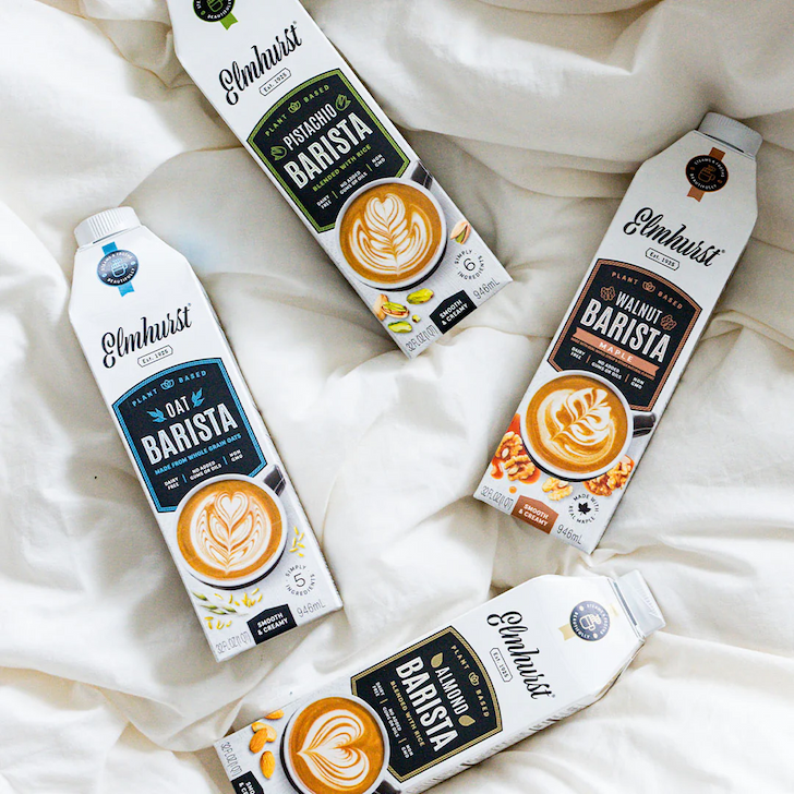 Variety of Barista milks on a creamy colored, fluffy comforter