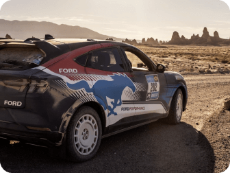 A Ford Mustang Mach‑E&reg; SUV being driven on a dirt road in the desert