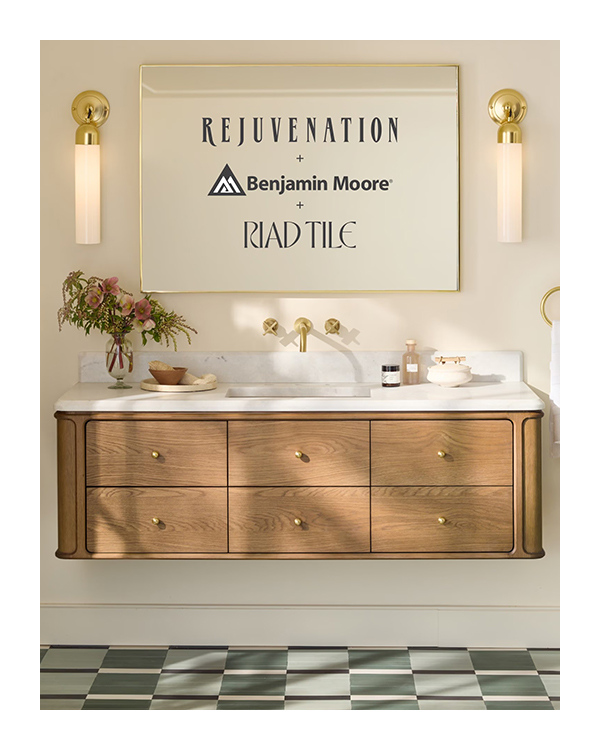 A floating wood vanity against a white-painted wall with gold fixtures and gold-topped sconces on either side of a square, gold-rimmed mirror.