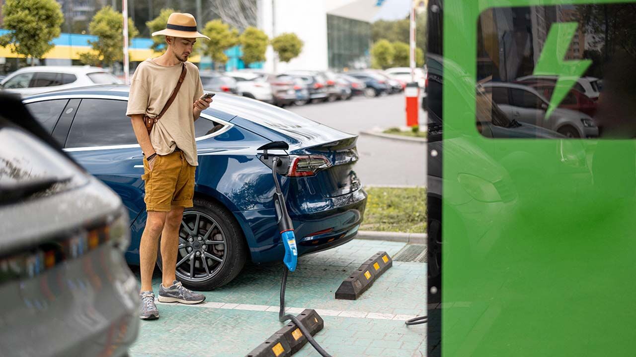 Man charging electric car on a public charging station