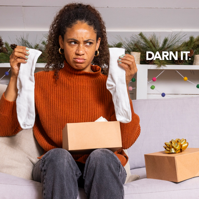 Submit your photo and earn points - Darn It. A gift recipient disappointedly holds up cotton socks.