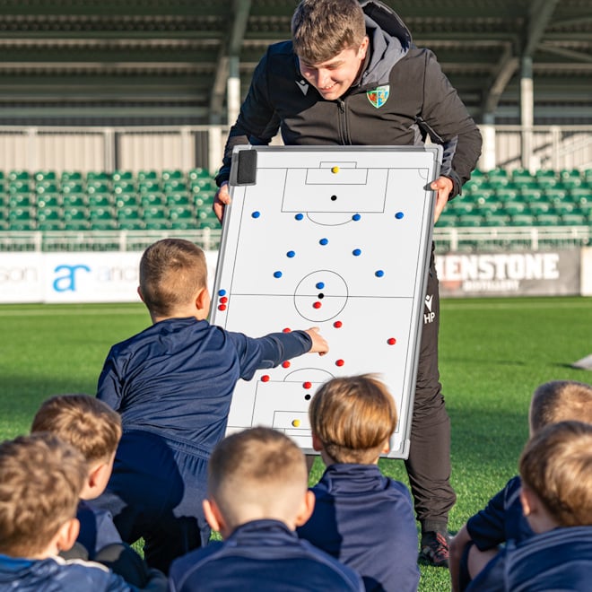 Coach setting up match play with the team using the FORZA Double-Sided tactics board.