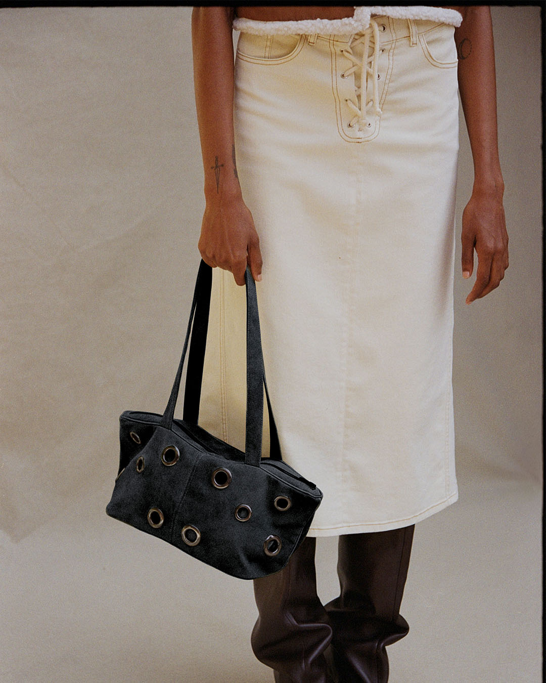 Beige denim skirt and navy bag