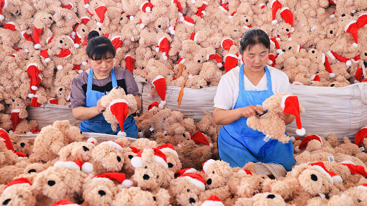 Workers produce Christmas stuffed toys for export at a toy factory in Lianyungang, China