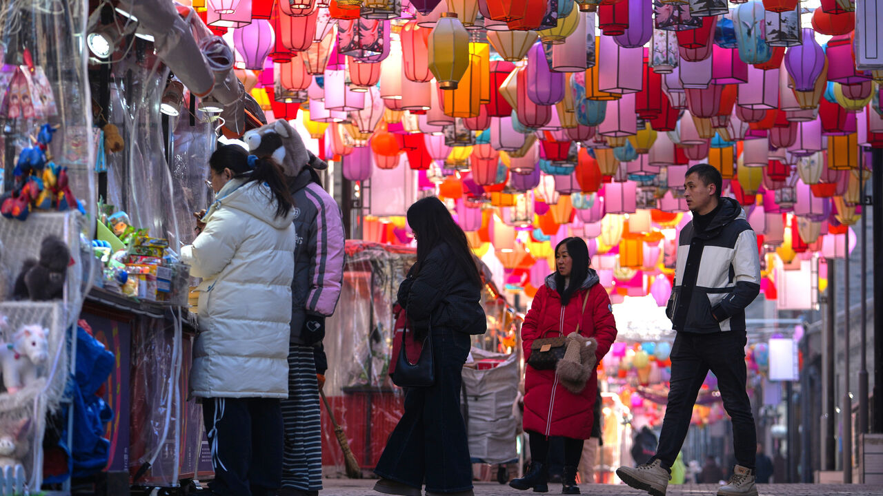 Visitors walk along souvenir stores at the Qianmen shopping street with lantern decorations in Beijing.