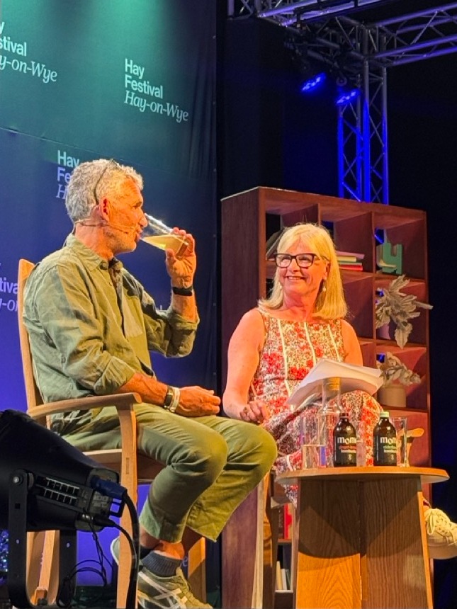 Tim Spector drinking a glass of MOMO on stage