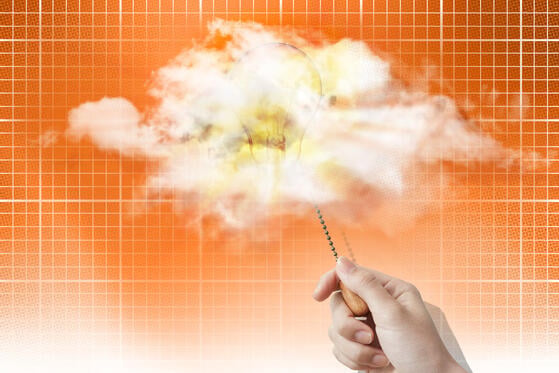 A photo illustration of a cloud floating in an orange sky with a light bulb in it shining after being turned on by a hand pulling on a chain.