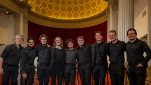 students wearing black pose for photo in theater