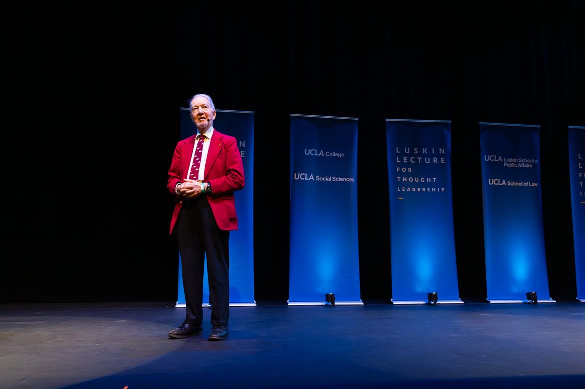 Jared Diamond wearing red jacket and tie on stage at Royce Hall