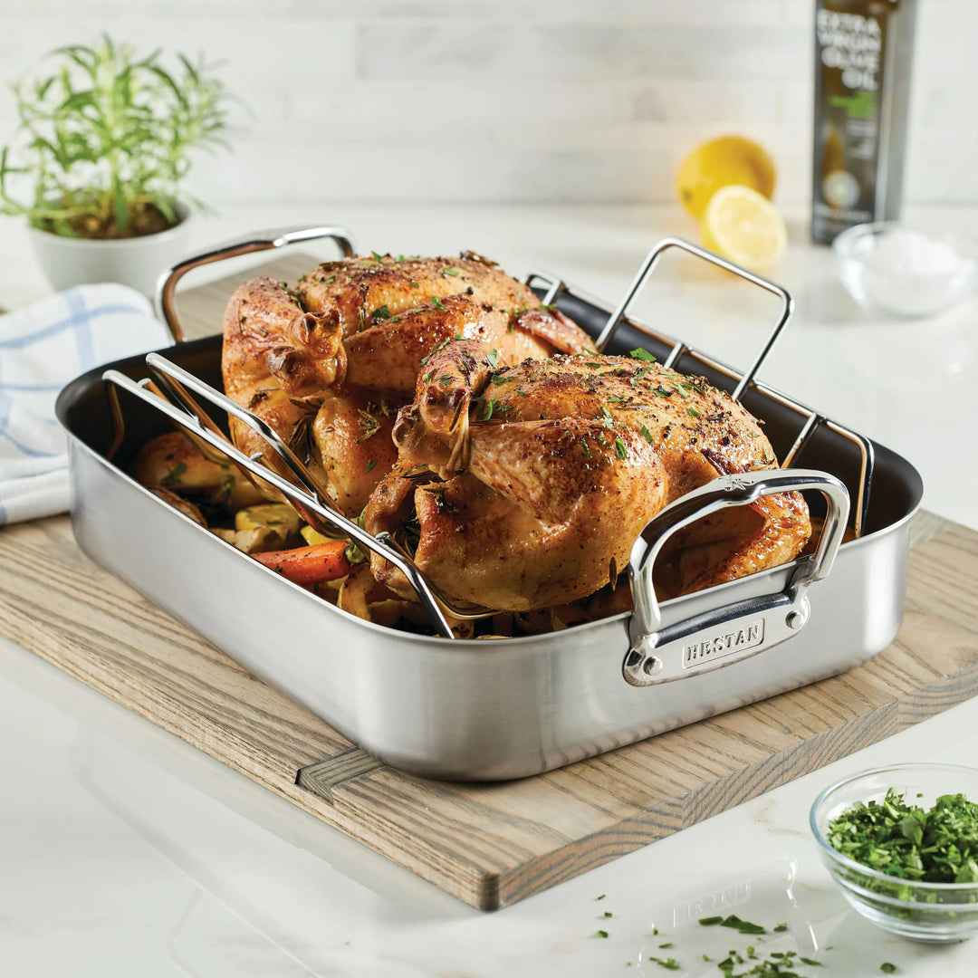 IMG: Roasted chicken in Hestan Roaster displayed in wooden board on marble countertop