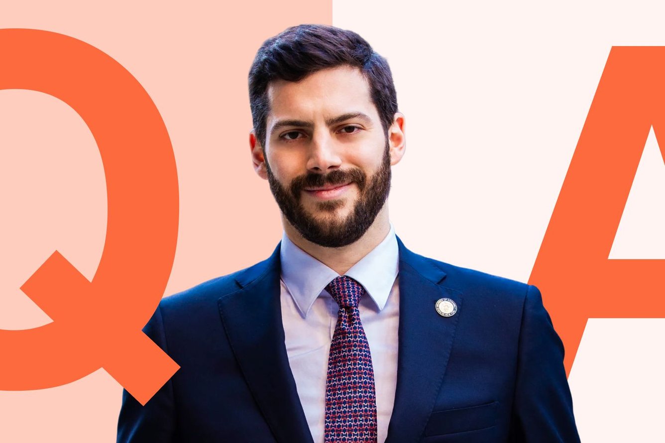 A portrait of NY Assemblyman Alex Bores on a graphic with large Q&A letters