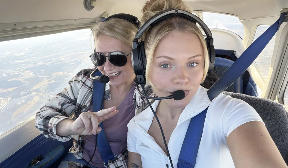 Two women in the cockpit of an airplane.
