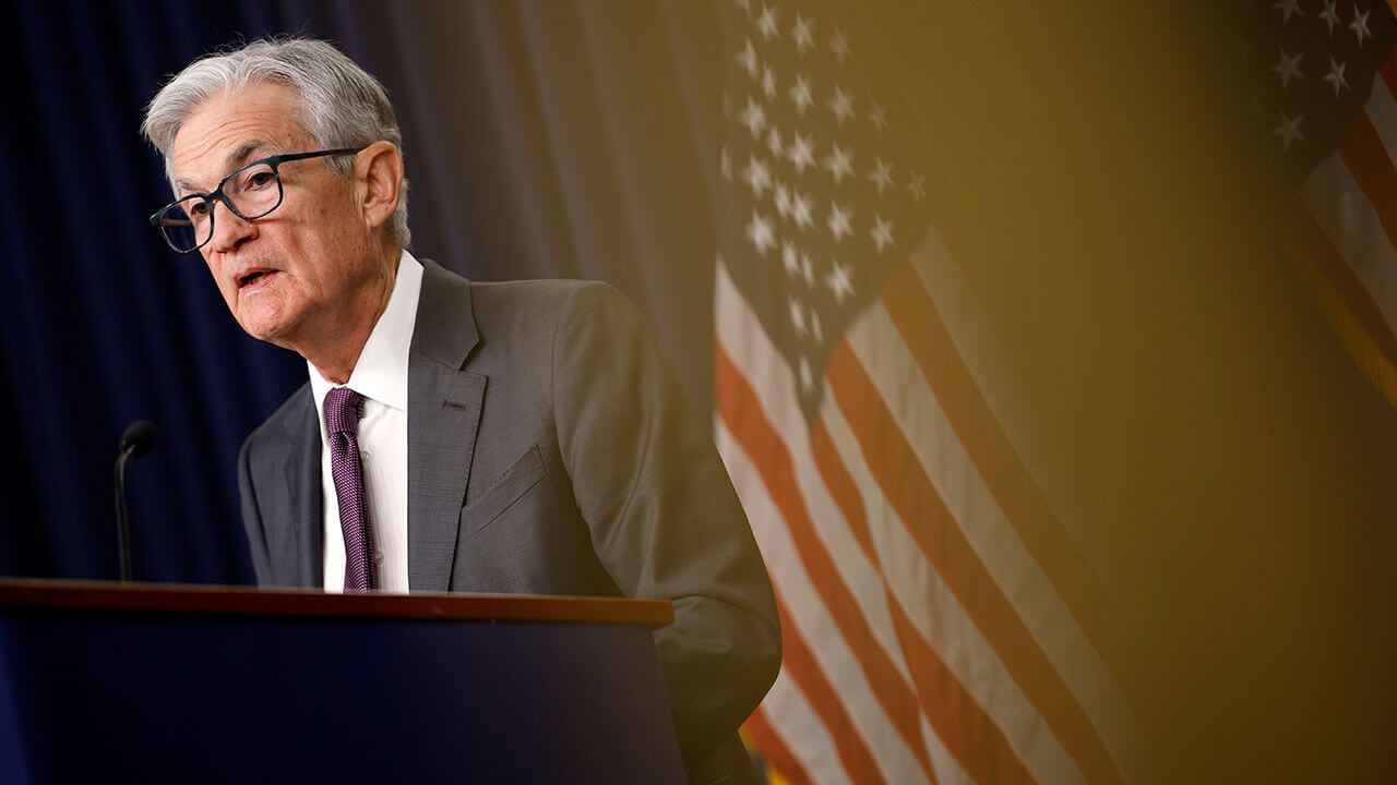 Federal Reserve Chairman Jerome Powell stands in front of the American flag