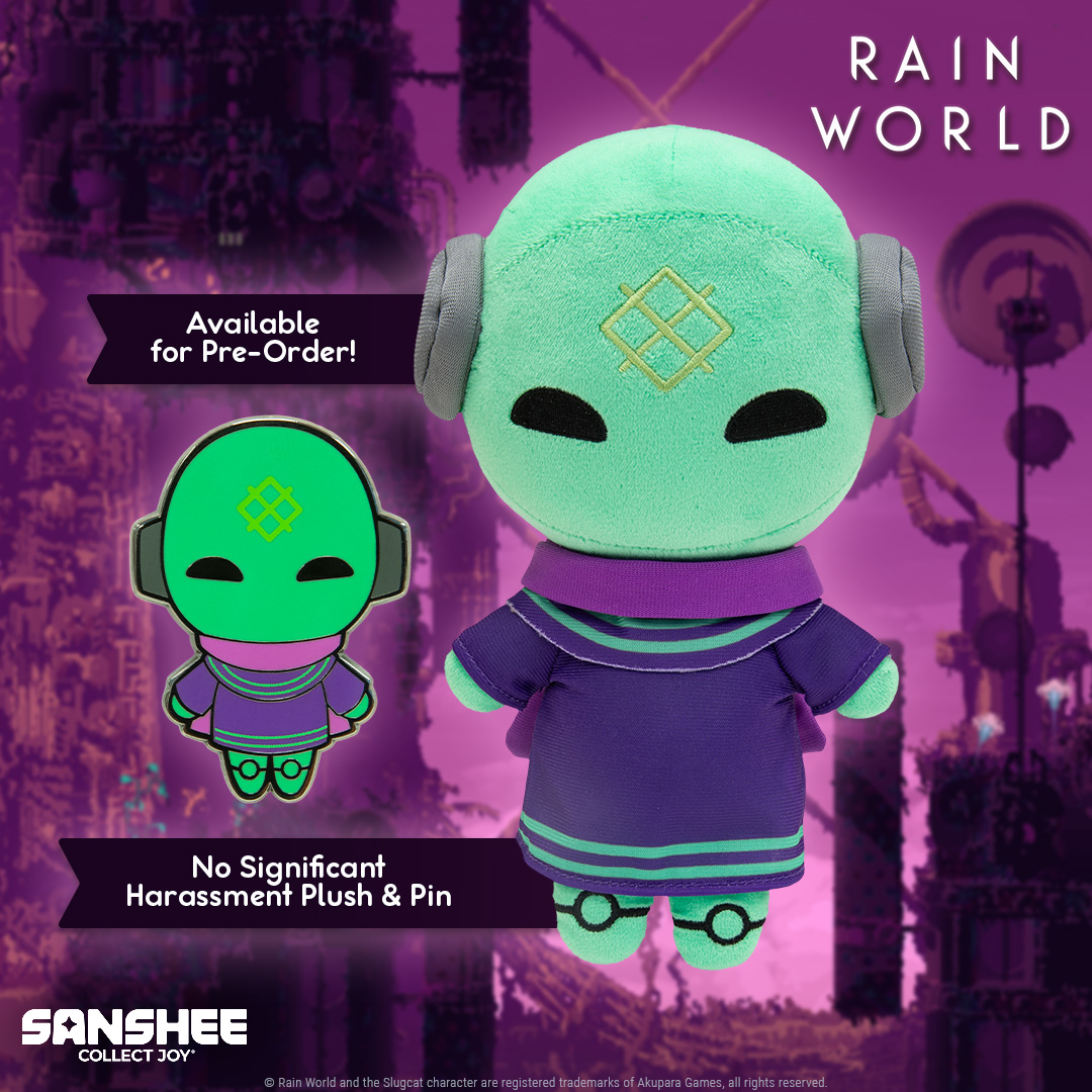 A green plush with purple clothes and purple scarf. There is a pin with the same design mock up on the left of it