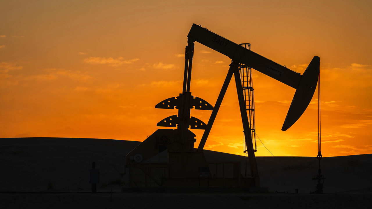 The silhouette of a pumpjack with the sunset in the background, near Crane, Texas, USA.