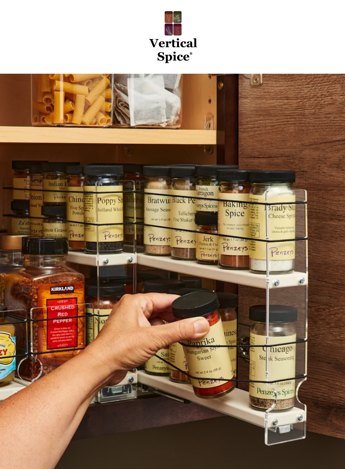 hand pulling paprika jar from a vertical spice rack drawer installed inside a wooden kitchen cabinet with multiple spice jars organized in sliding shelves