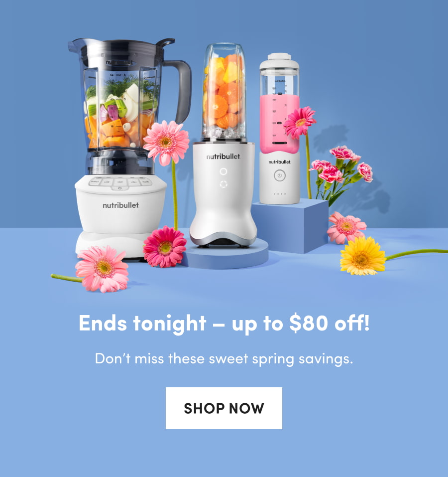 A studio shot of three different nutribullet blenders filled with fresh produce and smoothies, styled with vibrant pink and yellow flowers on blue pedestals.