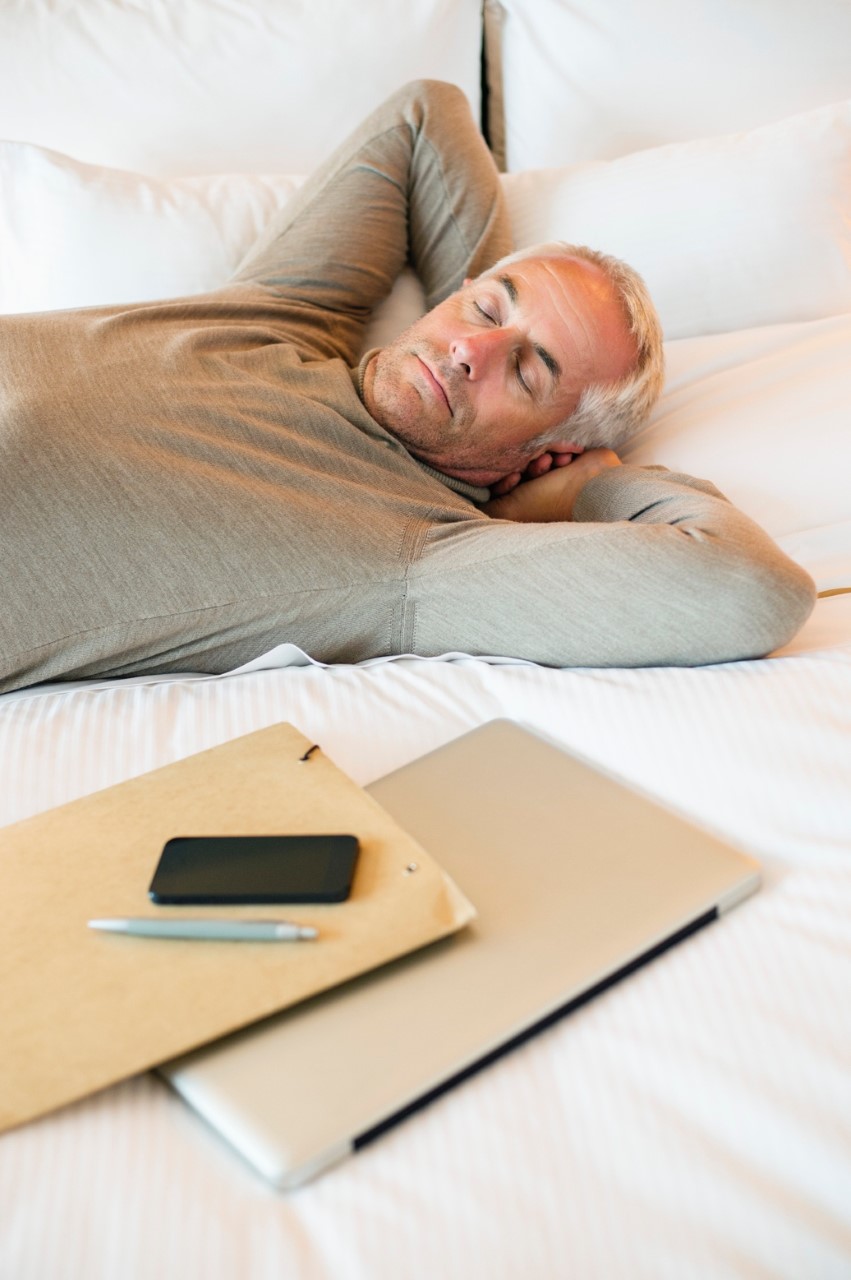 middle-aged man napping on 
his bed