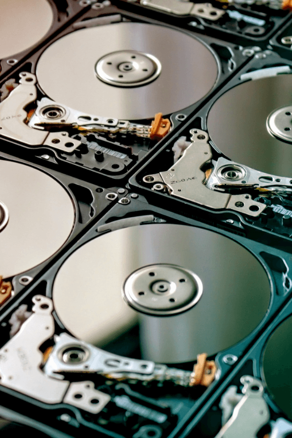 Close-up of several open hard drives arranged in a grid pattern, showing shiny metallic disks and intricate components, conveying a technological theme.