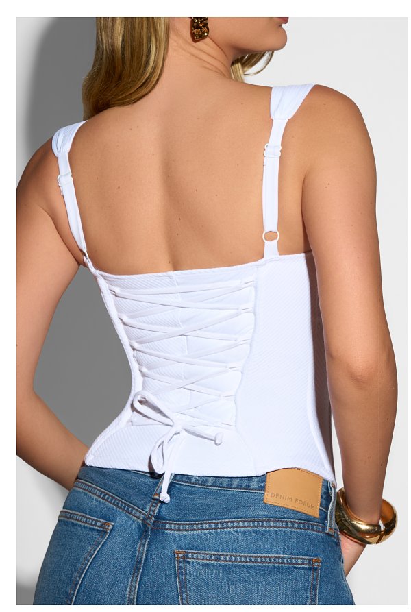 White top with lace-up back detail, worn with blue jeans.