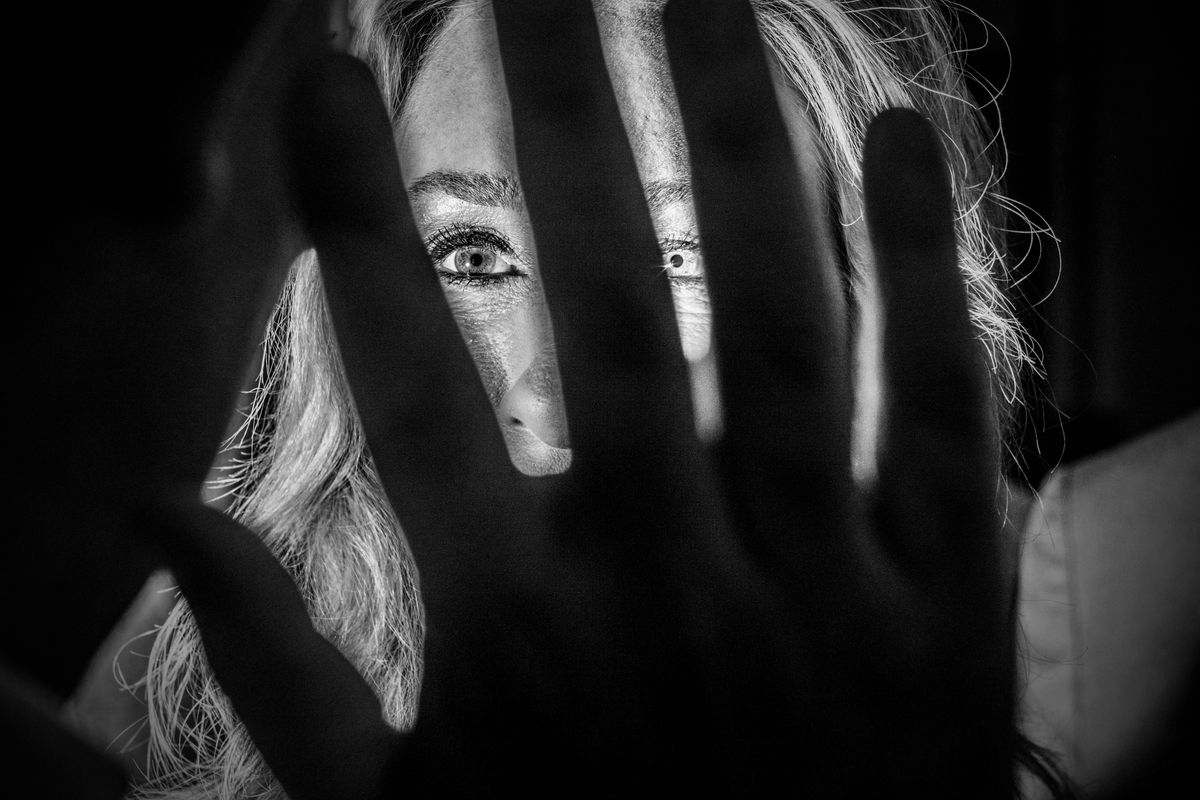 A hand in front of a woman's face