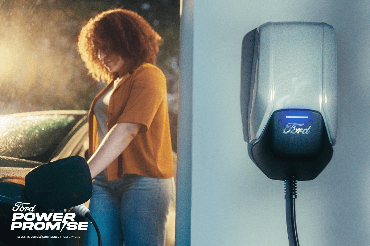 A woman charging her electric vehicle next to an image of the Ford Connected Charge Station