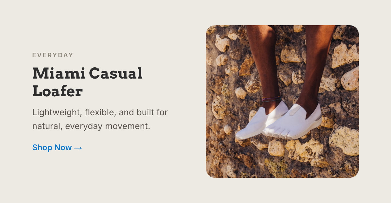 Feet in Peluva Miami Casual Loafers standing on a rocky shoreline