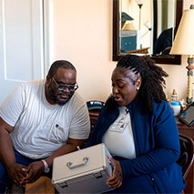 Penn Medicine staff holding a box at a patient's home.
